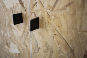 Gros plan dâun mur en bois sur lequel on aperçoit deux objets carrĂ©s noirs, qui pourraient ĂȘtre des prises Ă©lectriques ou des luminaires.
