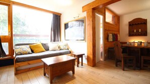 Una habitación acogedora con un sofá y una mesa de centro de madera, además de un comedor con mesa y sillas.