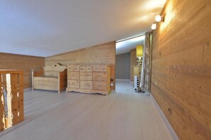 A room with wooden walls and a large wooden dresser with multiple drawers.