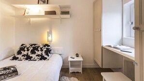 Un dormitorio con cama, mesita de noche y ventana con vistas.