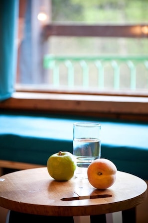 A round wooden table with a green apple, an orange, and a glass of water. - 100m from resort center, 10th floor, balcony, tv, 27m², Les Arcs (Les Arcs)