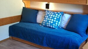 A cozy room with a wooden bed, a small table, and a wooden ceiling. - 50m from resort center, 13rd floor, 13m², Les Arcs (Les Arcs)