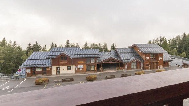 Eine Lodge mit mehreren Gebäuden, einem Parkplatz und bewaldeter Umgebung.