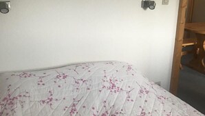 Een bed met een gewatteerd laken met een bloemenmotief.