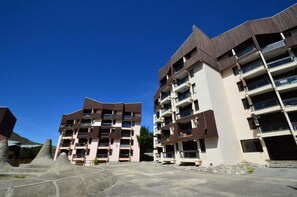 A modern multi-story residential building with balconies and a flat roof.