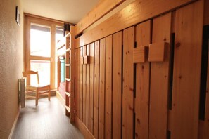 Stylish hallway with a door at the end, featuring a chair and radiator.