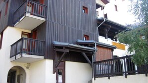 Ein mehrstöckiges Gebäude mit Balkonen, einer Treppe und einem kleinen Fenster.