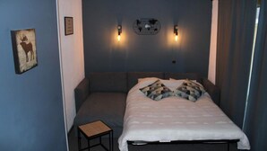 Ein Schlafzimmer mit einem Bett, einem kleinen Tisch und zwei Wandleuchten.