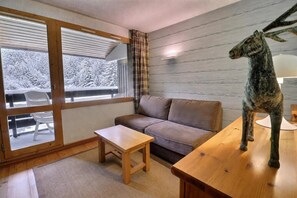 A cozy room with a sofa, a small table, and a wooden bench.