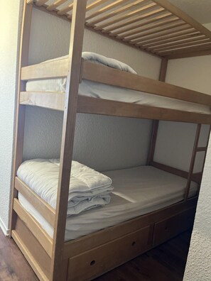 A bunk bed with two levels, each with a pillow and a folded blanket. - 300m from ski slopes, floor -2, balcony, tv, 25m², Pra Loup (Pra Loup)