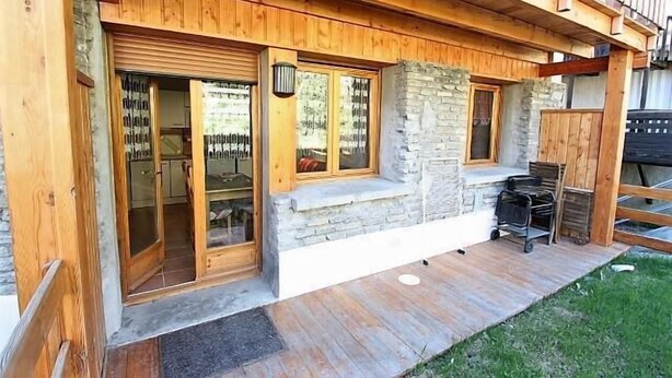 A wooden cabin with a stone fireplace, sliding glass doors, and a wooden deck. - Ground floor, terrace, tv, 40m², Pra Loup (Pra Loup)