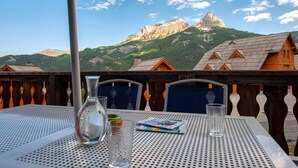 A table with a view of mountains and wooden cabins.