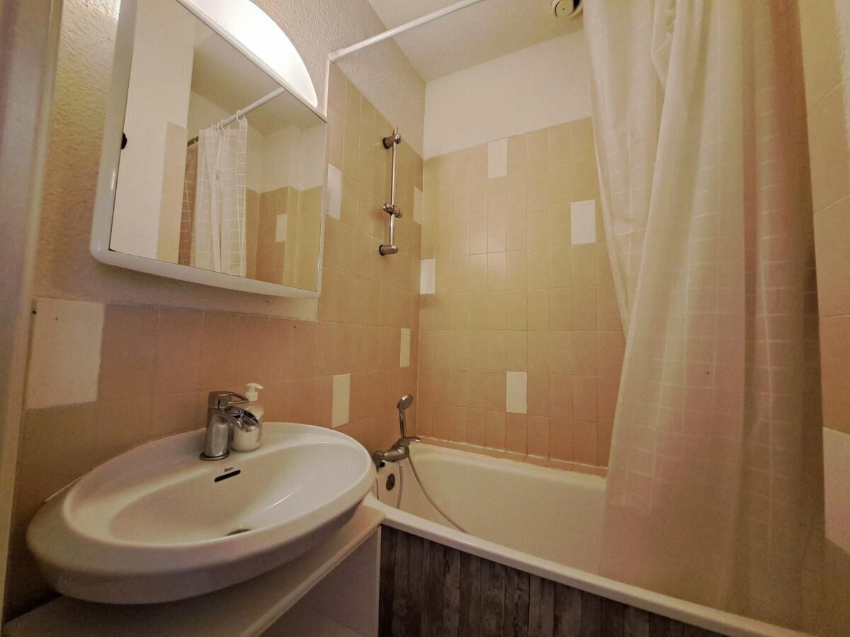 Un baño con lavamanos, espejo, ducha y bañera.