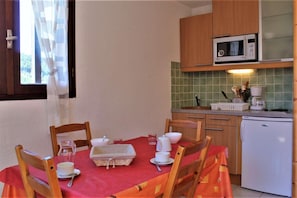 Enjoy meals in this cozy kitchen with a dining table set for two, microwave, refrigerator, and coffee maker.