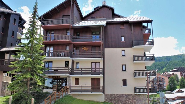 A multi-story hotel with balconies, a wooden facade, and a sign reading "AIRELES B". - 100m from ski slopes, 1st floor, balcony, tv, ski locker, 28m², Risoul (Risoul)