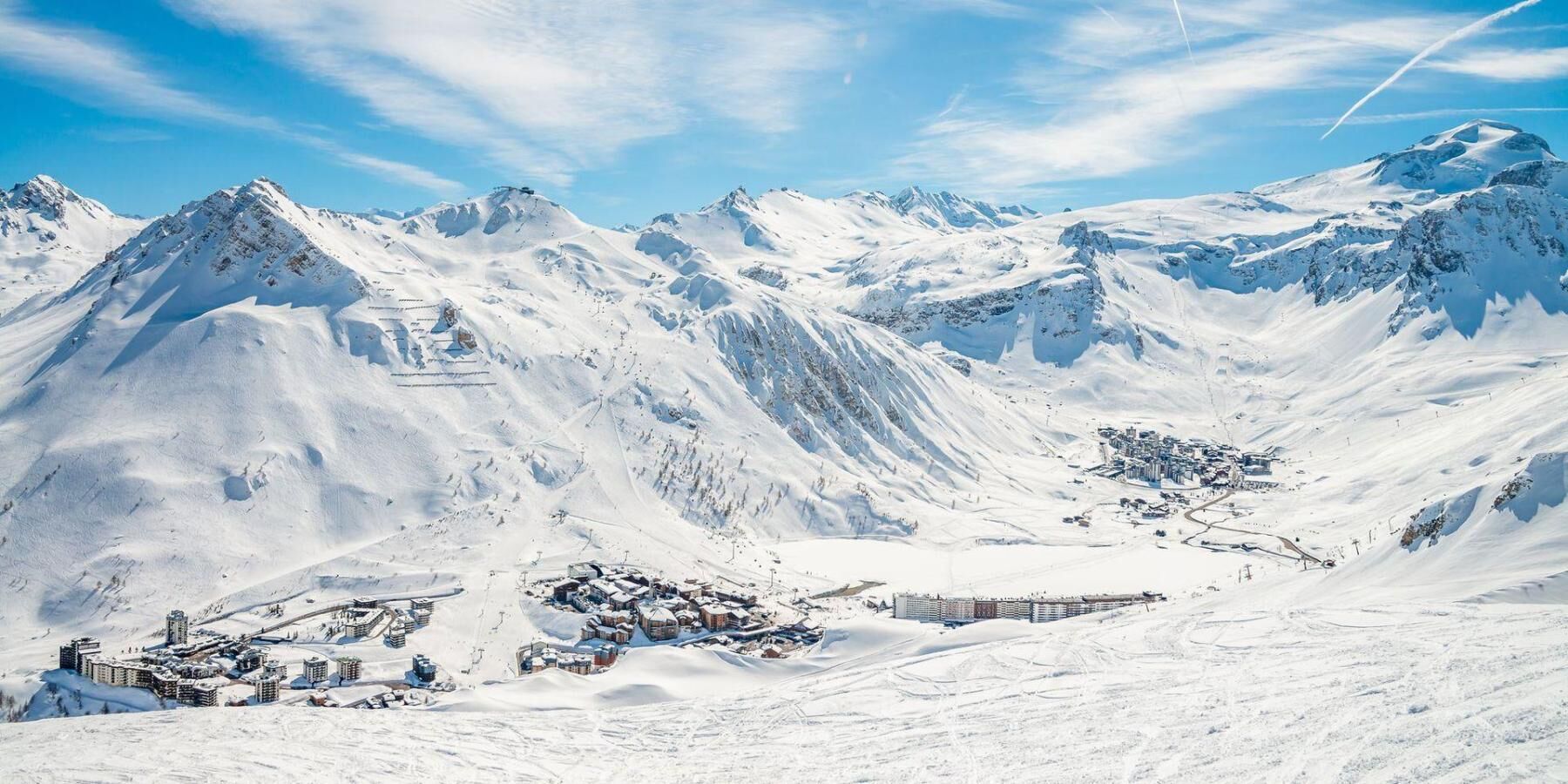 A snow-covered mountain landscape with a small town and buildings at the base.