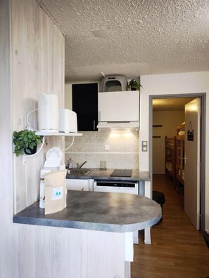 A compact kitchen with a built-in dishwasher, a small countertop, and a microwave.