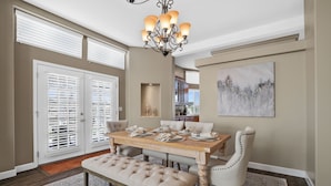 A dining area with a wooden table, cushioned bench, and a chandelier. - 2 Patios, BBQ, Center Wine Country (Temecula)