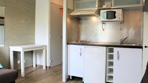 A compact kitchen with white cabinets, a microwave, and a small dining table. - 100m from ski slopes, 3rd floor, tv, ski locker, 18m², Vars (Vars)