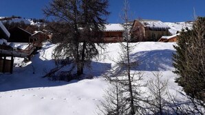 Un paysage enneigé avec une cabane en bois et un pont.
