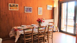 A dining area with a wooden paneled wall, a table set for four, and three framed pictures above the table. - 100m from ski slopes, 2nd floor, balcony, tv, 65m², Vars (Vars)