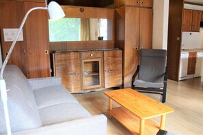 Cozy living space with a kitchenette, sofa, chair, and table.