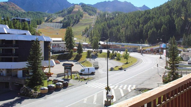 A road with a curve, a white van, and a building with a sign that reads "Vais". - Resort center, 3rd floor, balcony, tv, 30m², Vars (Vars)