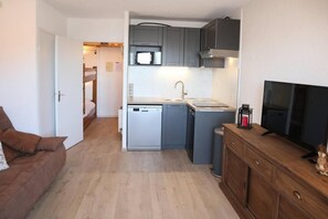 A compact kitchen with grey cabinets, a microwave, and a dishwasher.