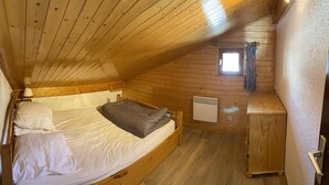 A small, cozy room with a single bed, a small window, and a heater. - 100m from ski slopes, 2nd floor, view ski slopes/mountain, tv, 60m², Les Saisies (Les Saisies)
