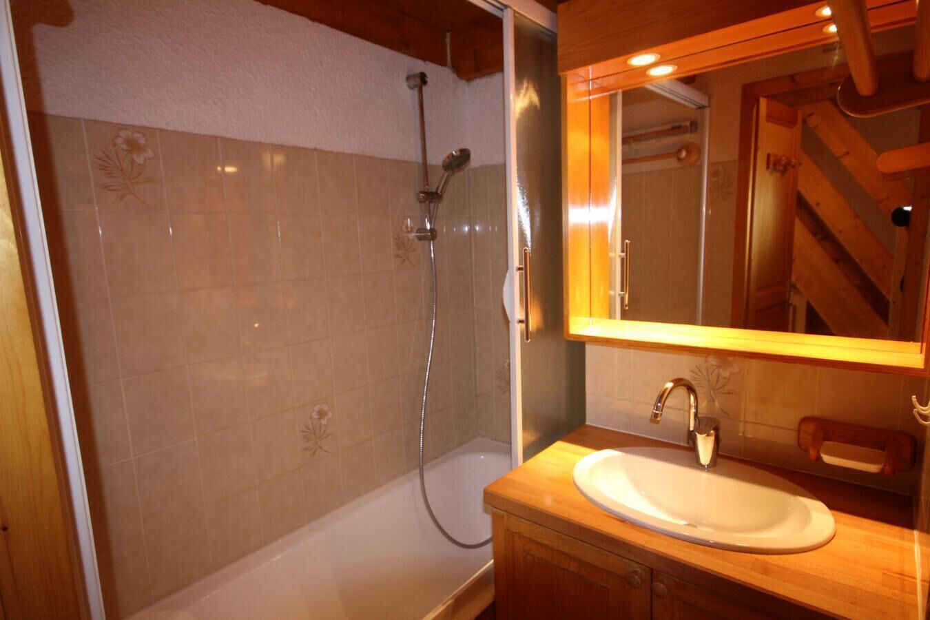 Ein Badezimmer mit Badewanne, Dusche, Waschbecken und Spiegel.
