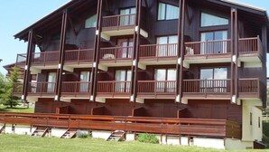 A multi-story wooden building with balconies, likely a hotel or apartment complex. - 100m from ski slopes, 2nd floor, view ski slopes/mountain, tv, 60m², Les Saisies (Les Saisies)