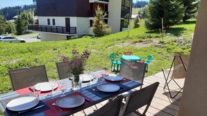 An outdoor dining area with a table set for four, surrounded by chairs. - 100m from ski slopes, Ground floor, terrace, tv, ski locker, 47m², Les Saisies (Hauteluce)