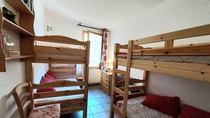 Una habitación con literas, un escritorio y una silla.