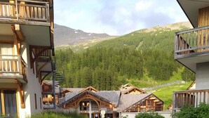 A rustic mountain lodge with wooden cabins and a gravel driveway leading to a wooden deck. - 250m from ski slopes, 5th floor, swimming pool, balcony, tv, ski locker, 60m², Les Orres (Les Orres)
