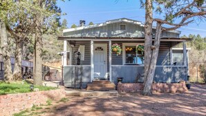 A single-story house with a front porch, a small attached garage, and a brick foundation. - Cozy Cottage Getaway  (Payson)