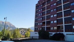 Um edifício de vários andares com design arquitetônico moderno, com uma série de varandas e janelas amplas.