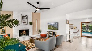 A modern living room with a fireplace, grey sofas, and a TV.