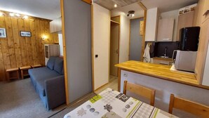 A compact room with a sofa, a small dining table, and a kitchenette area. - 50m from resort center, 2nd floor, balcony, tv, ski locker, 26m², Montchavin La Plagne (Bellentre)