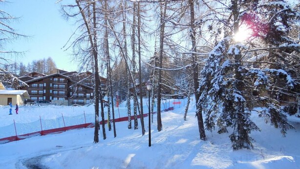 A snow-covered pathway leading to a building with multiple windows and a red fence. - 50m from resort center, 2nd floor, balcony, tv, ski locker, 26m², Montchavin La Plagne (Bellentre)