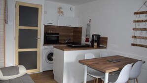 A compact kitchen with a washing machine, a microwave, and a coffee maker. - 1st floor, balcony, tv, ski locker, 21m², Pralognan-la-Vanoise (Pralognan-la-Vanoise)