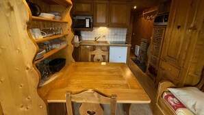 Uma cozinha compacta com armários de madeira, micro-ondas e pia.