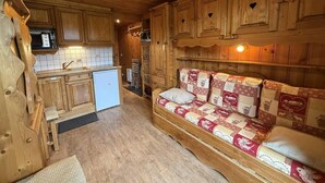 Um quarto acolhedor em estilo cabana, com paredes de madeira e um sofá embutido com capa acolchoada.