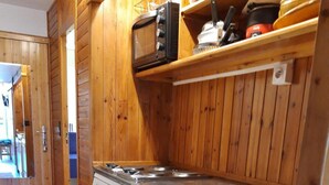 A compact kitchen with wooden paneling, a microwave, a dishwasher, and a sink. - 100m from ski slopes, 6th floor, balcony, tv, 25m², Les Arcs (Les Arcs)