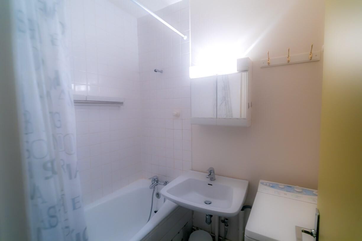 A bathroom with a bathtub, sink, and a washing machine.