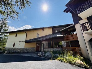A modern building with a stone facade, a wooden deck, and a clear sky. - 180m from ski slopes, 3rd floor, balcony, tv, ski locker, 34m², Peisey-Vallandry (Landry)