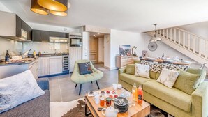 A modern kitchen with a dining area, a sofa, and a coffee table with breakfast items. - 50m from ski slopes, 7th floor, swimming pool, sauna, hammam, balcony, tv, ski locker, 72m², Tignes (Tignes)