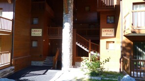 A wooden building with multiple balconies and staircases. Signs on the building read "CHALET" and "Chalet." - Ski-in/ski-out & foot of the slopes, 1st floor, view ski slopes, balcony, tv, ski locker, 65m² (Les Arcs)
