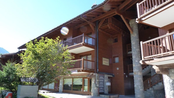 A wooden building with balconies and a sign that reads "CHALET Nature".