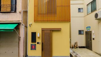 Un edificio con facciata gialla, una porta in legno e un'insegna che indica un ristorante.