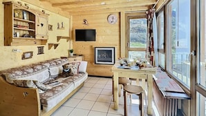 Un intérieur en bois avec un canapé, une table et un téléviseur.